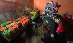 Petugas Sat Samapta Polres Gresik mengamankan penjual dan barang bukti miras saat penggerebekan warung remang-remang di Desa Lowayu, Kecamatan Dukun.