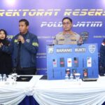 Petugas Ditressiber Polda Jawa Timur menunjukkan barang bukti kasus registrasi SIM card ilegal dan layanan OTP digital.