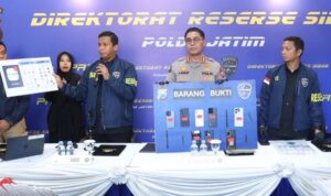 Petugas Ditressiber Polda Jawa Timur menunjukkan barang bukti kasus registrasi SIM card ilegal dan layanan OTP digital.