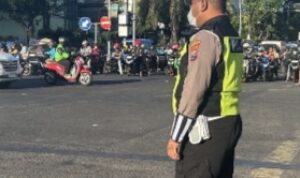 Anggota Polsek Tambaksari berjaga dan mengatur lalu lintas di Perempatan Kedung Cowek, Surabaya