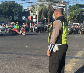 Anggota Polsek Tambaksari berjaga dan mengatur lalu lintas di Perempatan Kedung Cowek, Surabaya