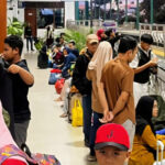 Petugas KAI Commuter melayani penumpang di tengah lonjakan pengguna Commuter Line Wilayah 8 Surabaya saat libur panjang.
