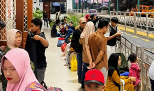 Petugas KAI Commuter melayani penumpang di tengah lonjakan pengguna Commuter Line Wilayah 8 Surabaya saat libur panjang.