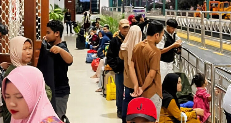 Petugas KAI Commuter melayani penumpang di tengah lonjakan pengguna Commuter Line Wilayah 8 Surabaya saat libur panjang.