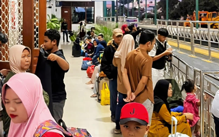 Petugas KAI Commuter melayani penumpang di tengah lonjakan pengguna Commuter Line Wilayah 8 Surabaya saat libur panjang.