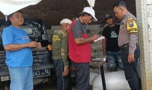 Petugas Bulog Pasuruan dan personel Polsek Sukorejo mendampingi penyerapan hasil panen jagung petani di Desa Kenduruan.